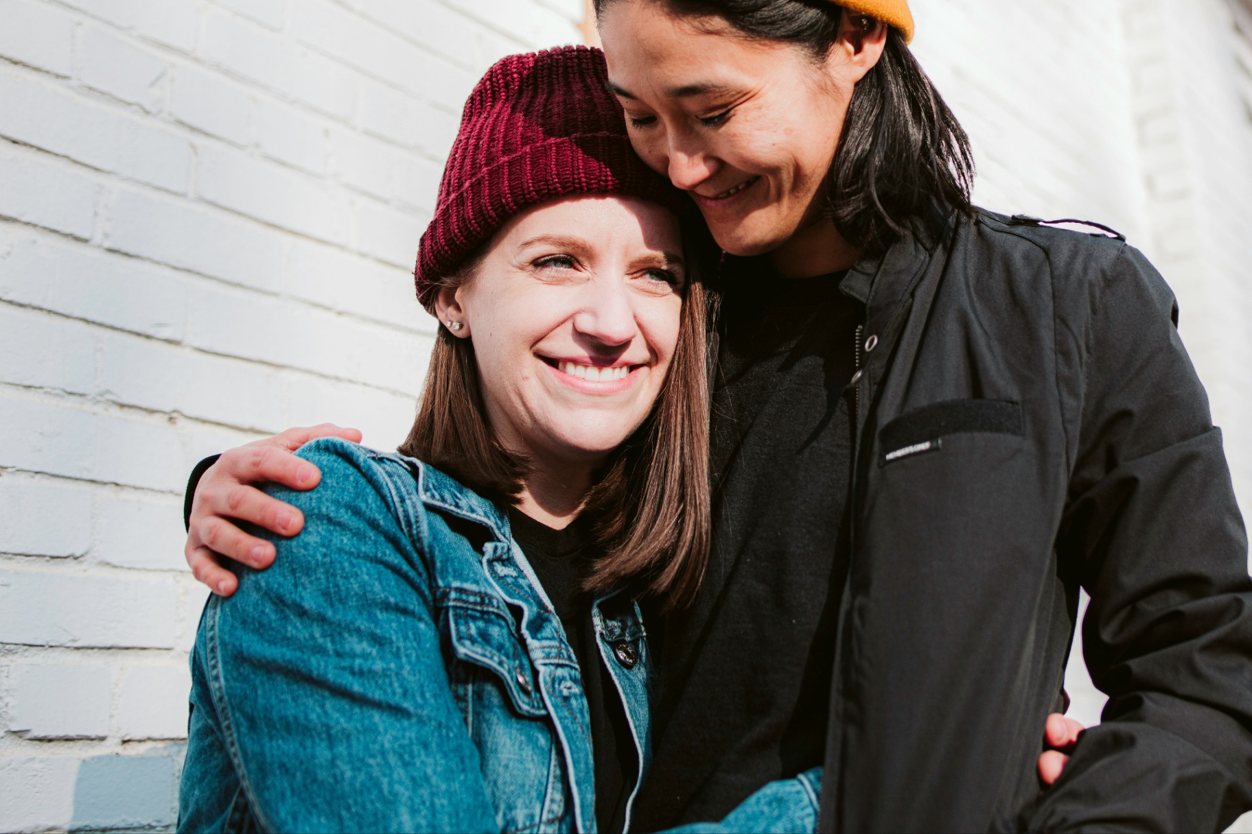 lesbian couple hugging and smiling both wearing winter hats, Katheryn Barton Uplift and Connect Counseling, Kirkwood, Missouri